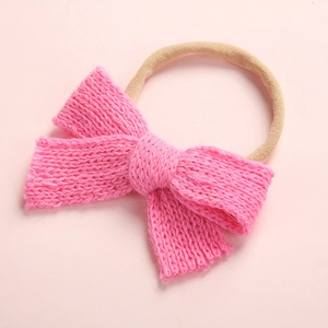 Detailed view of the soft knitted pink bow and elastic nylon band for baby girls