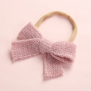 Soft pink knit bow baby headband with stretchy nylon strap for infants and newborns