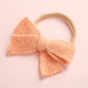 Detail of soft knit apricot pink bow headband with elastic seamless band for baby girls