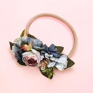 Détail d'un bandeau élastique pour bébé avec fleurs de pivoine en tulle bleu et rose