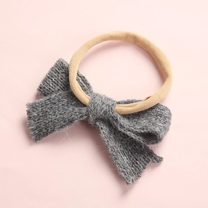 Detailed view of grey knitted bow baby headband with soft high-elastic nylon band