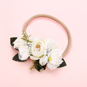 Bandeau pour bébé fille avec fleurs en gaze blanche et feuilles vertes sur fond rose poudré