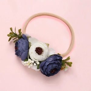 Vue détaillée du bandeau bébé avec fleurs en maille faites main et pétales de soie bleue