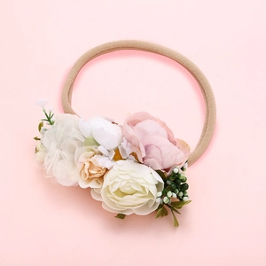 Détail d'un bandeau bébé avec pivoines roses, roses blanches et petites baies vertes
