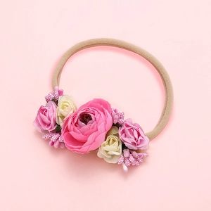 Détail d'un bandeau pour bébé avec roses roses douces et sangle en nylon élastique