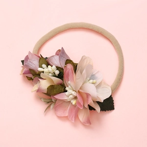 Détail de fleurs en tissu doux avec étamines perlées sur un bandeau en nylon beige souple
