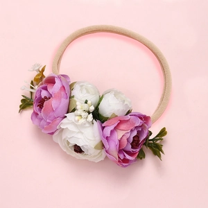 Détail d'un bandeau pour bébé avec fleurs en soie rose et bande en nylon élastique