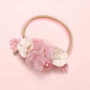 Détail de fleurs en mousseline rose et marguerite sur bandeau élastique pour bébé