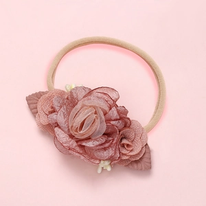Bandeau bébé fait main avec fleur en résille vieux rose et baies sur fond rose doux