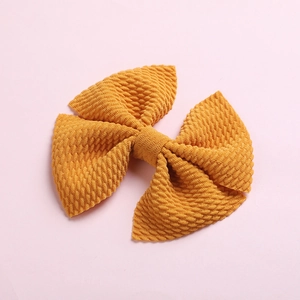 Close-up of ginger yellow waffle texture fabric bow hair clip for girls and babies