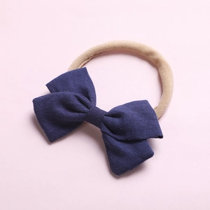 Détail du nœud bleu foncé sur un bandeau sans couture doux pour nourrissons et bébés