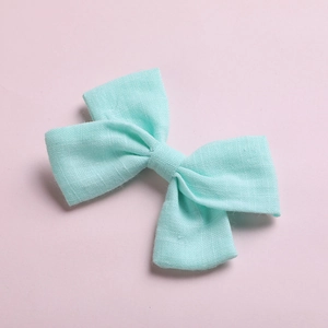 Detail of mint green slub cotton bow hair clip with textured fabric for girls