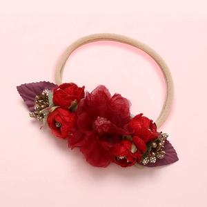 Détail du bandeau bébé avec fleur en tulle bordeaux et boutons de roses en tissu rouge