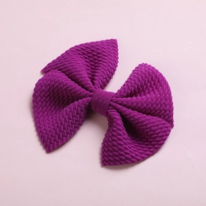 Detailed close-up of purple waffle fabric hair bow clip with soft textured waffle weave