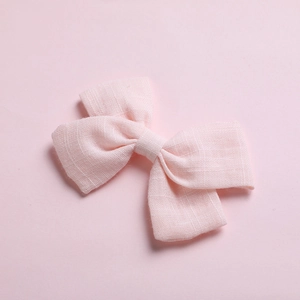 Close-up of pink cotton bow hair clips showing textured fabric and dual-layered design