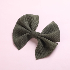 Close-up of olive green waffle knit fabric hair bow for girls with detailed texture