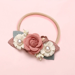 Détail du bandeau fleuri pour bébé avec rose rose, fleurs blanches et nylon élastique