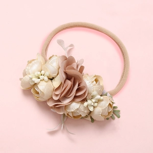 Détail du bandeau floral pour bébé avec bande en nylon souple et roses crème