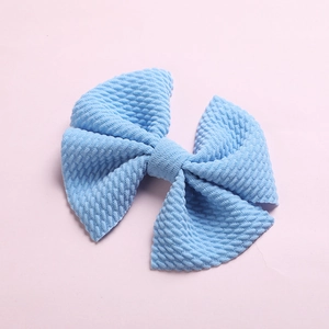 Detailed macro view of light blue waffle texture fabric bow hair clip for children
