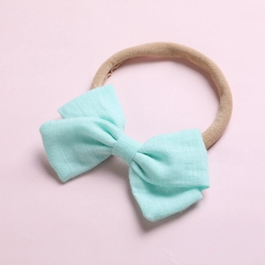 Détail du nœud en lin vert menthe doux et bandeau en nylon sans couture pour bébé