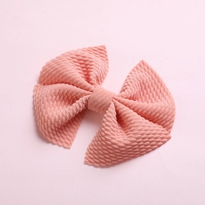 Detailed macro view of pink waffle knit texture on children's bow hair clip