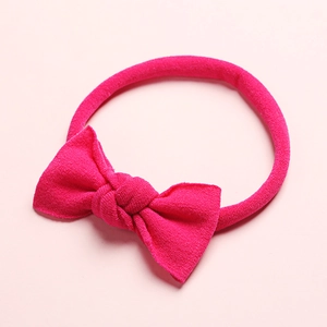 Gros plan sur un bandeau extensible rose vif pour bébé avec un détail de nœud doux