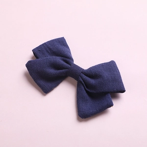 Detailed close-up of navy blue bamboo cotton bow hair clip with textured fabric weaving