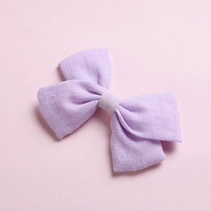 Detailed texture of lavender cotton bow hair clip featuring soft linen fabric weave