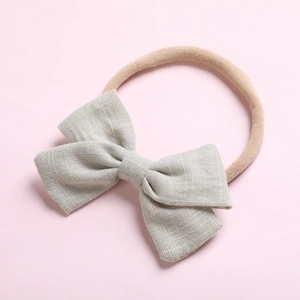 Détail du nœud en lin gris doux pour bandeau de bébé avec bande en nylon extensible