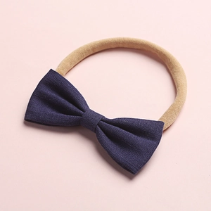 Dettaglio fascia per neonati con fiocco in lino blu scuro ed elastico in nylon morbido