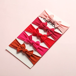 Set of 5 soft nylon baby headbands with bows in warm red and pink shades