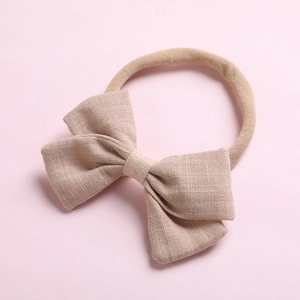 Détail du nœud en lin beige avec bandeau en nylon sans couture pour bébé
