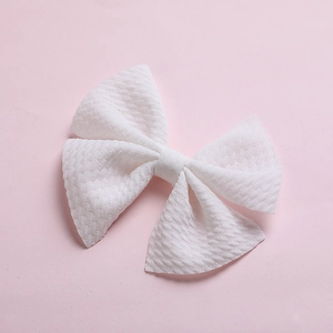 Detailed macro view of a white bubble fabric hair bow clip for infants and kids