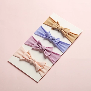 Set of four soft nylon baby headbands with handmade bows in multi-color pastel tones