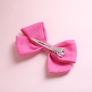 Detail showing the silver metal alligator clip on the back of a pink cotton bow hair clip