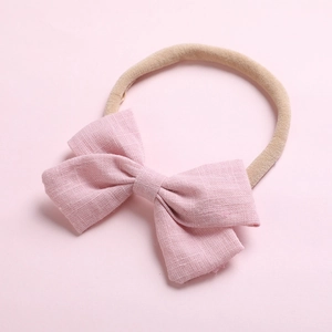 Détail du nœud en lin rose sur bandeau en nylon souple pour bébé accessoire de cheveux doux