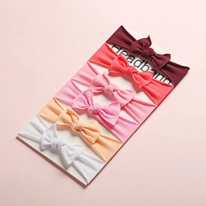 Detail showing set of six soft nylon baby headbands with textured knit bows on a card
