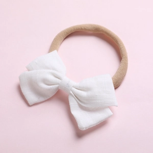 Détail d'un bandeau bébé montrant le nœud en coton blanc et la texture élastique douce