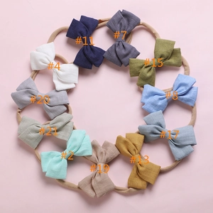 Bandeaux en nylon pour bébés avec nœuds en coton et lin présentés en onze couleurs variées