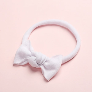 Gros plan d'un bandeau blanc ultra-doux en nylon pour bébé avec un joli nœud