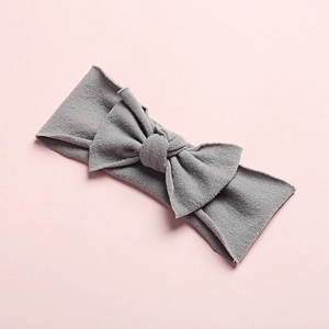 Macro detail of seamless soft nylon baby headband with classic grey knit bow decoration