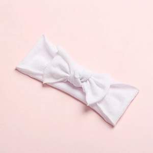 Close-up of soft white microfiber baby headband with a large decorative bow