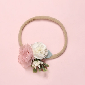 Close-up of soft chiffon flowers and green leaves on a high-elastic nylon baby headband