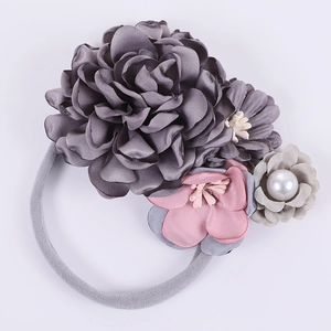 Détail de l'élastique à fleurs en satin de soie avec pétales gris et perle blanche