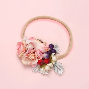 Detailed view of baby flower headband with pink roses, berries and soft nylon band
