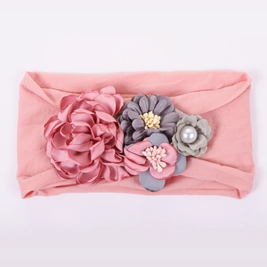 Détail du bandeau rose pour bébé avec fleurs en tissu et accents de perles élégantes
