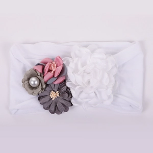 Détail de bandeau bébé avec fleurs en tissu faites main et ruban élastique blanc