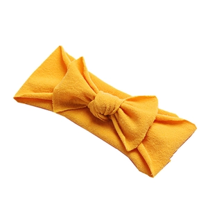 Soft nylon baby headband with a large mustard yellow waffle texture bow decoration