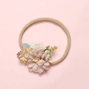 Detailed close-up of handmade mesh flower headband with nylon band and rhinestones