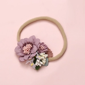 Detail of soft nylon infant headband with dusty pink fabric flowers and realistic leaves